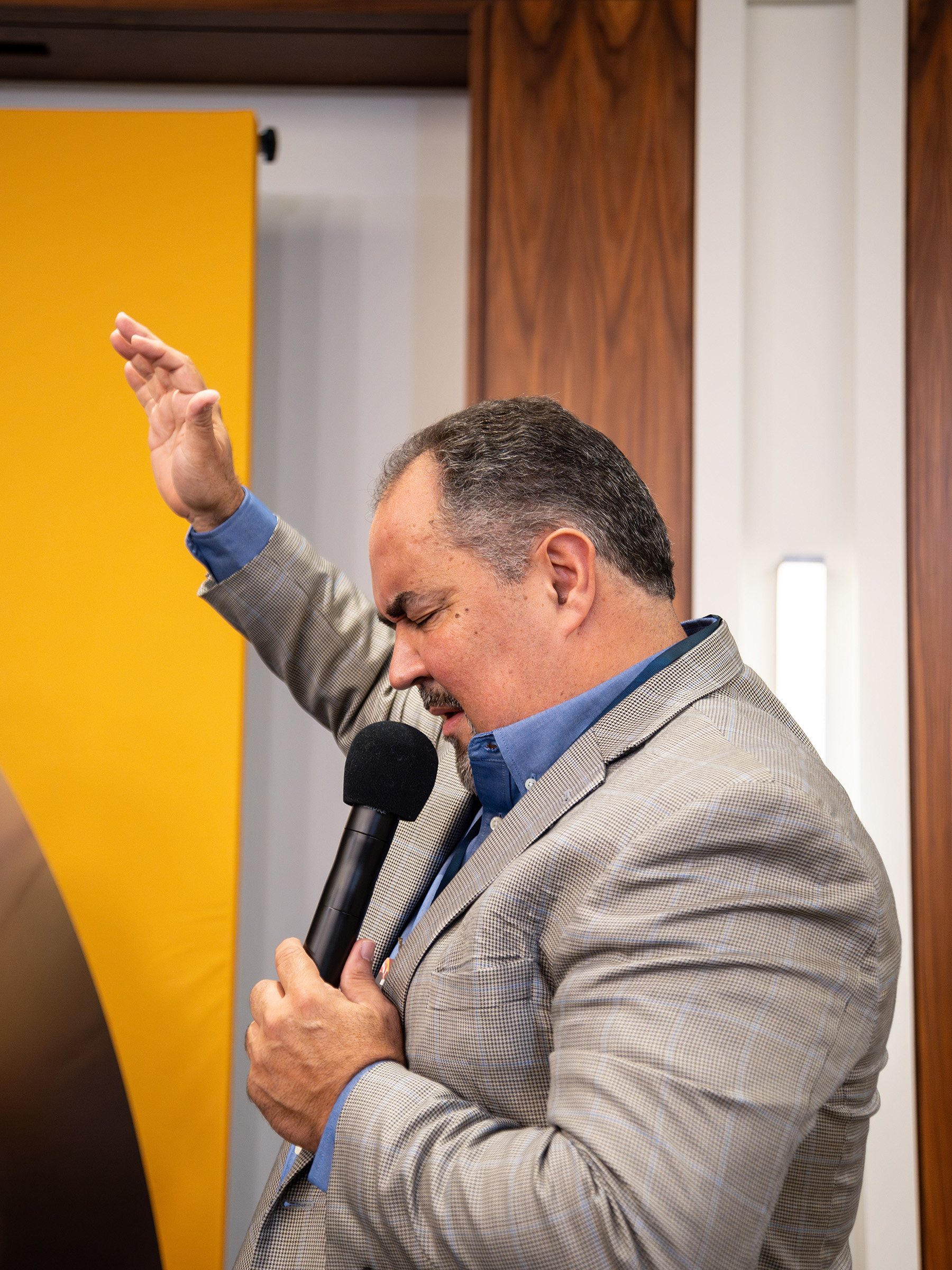 Hispanic man praying with his hand up