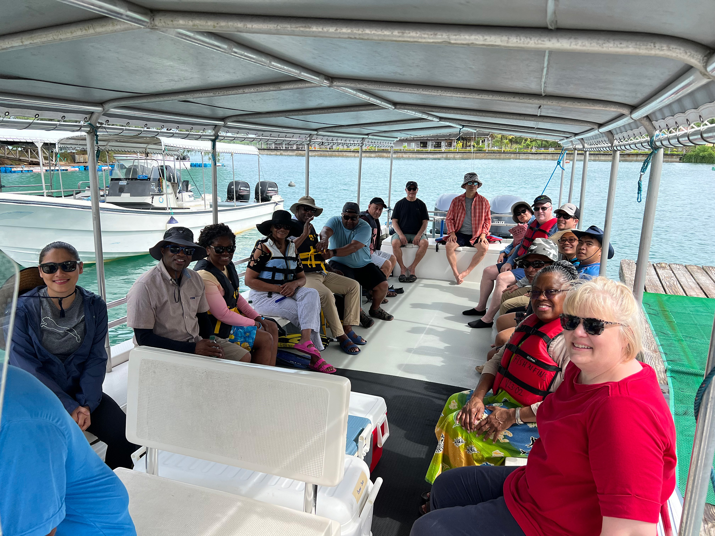 Several people of different ethnicities on a boat smiling