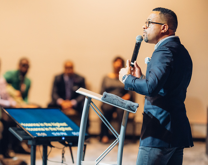 Black man speaking at a podium