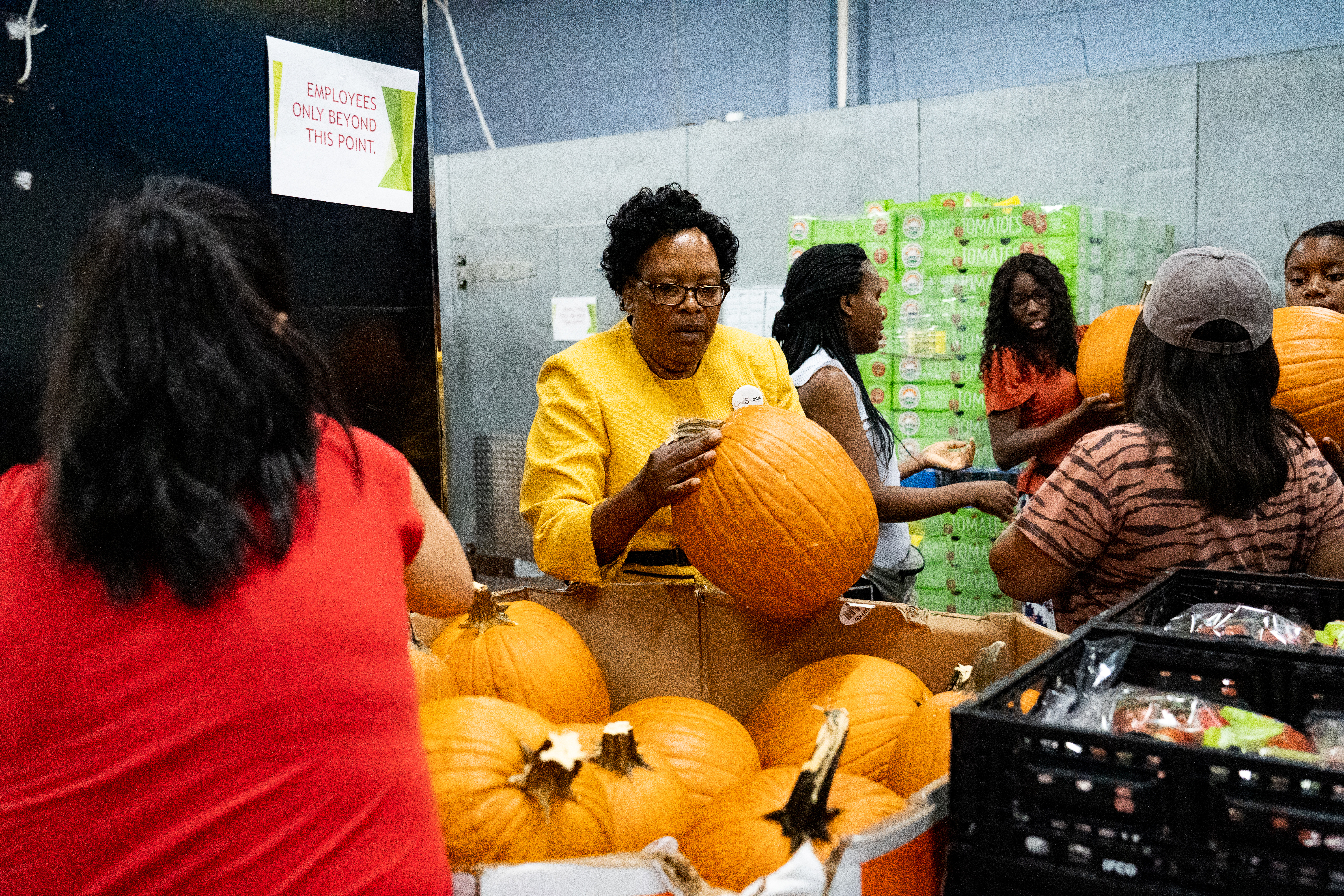 Volunteers organize pumpkins for the United Against Poverty grocery center