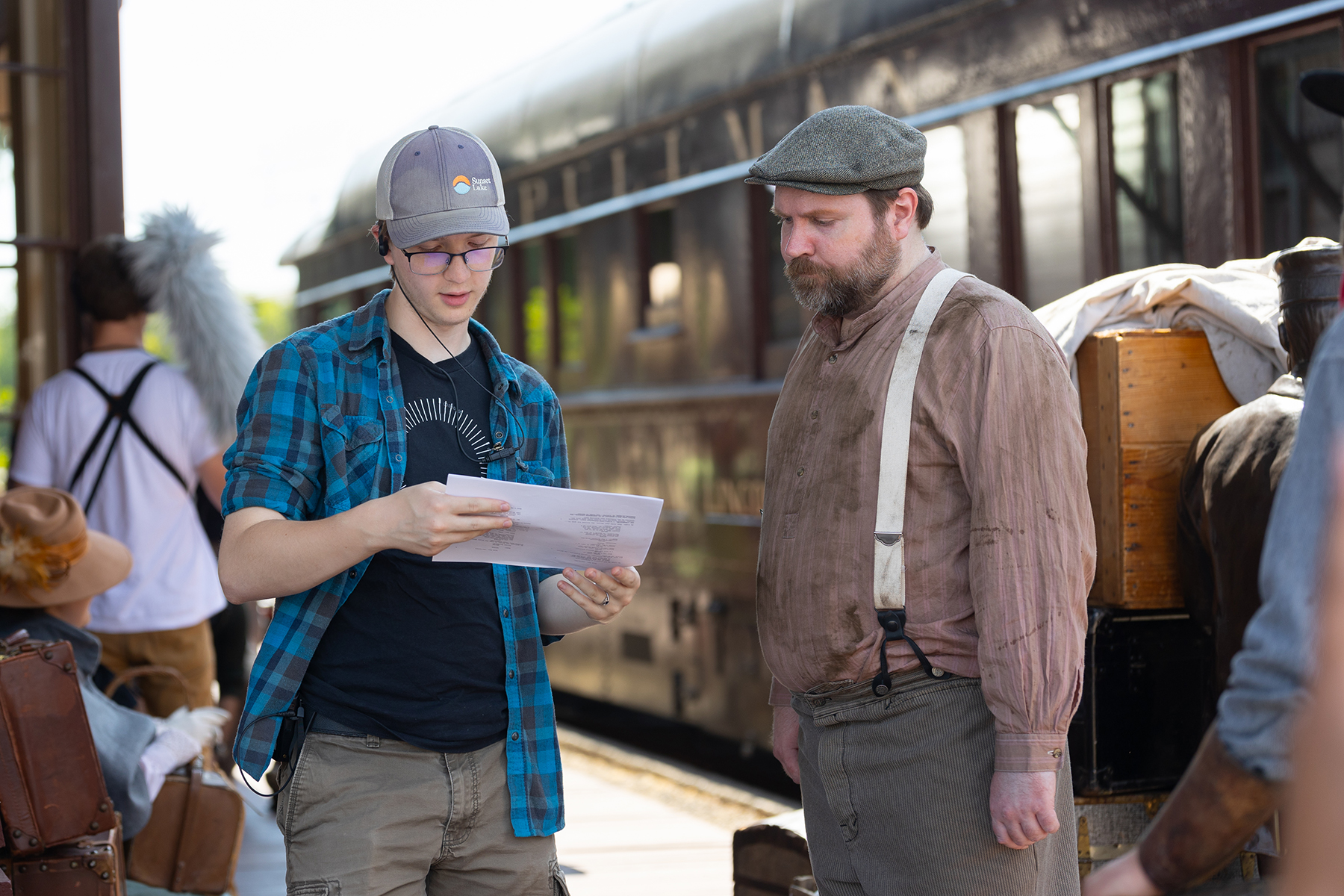 A student filmmaker, male, looks over a script with an actor