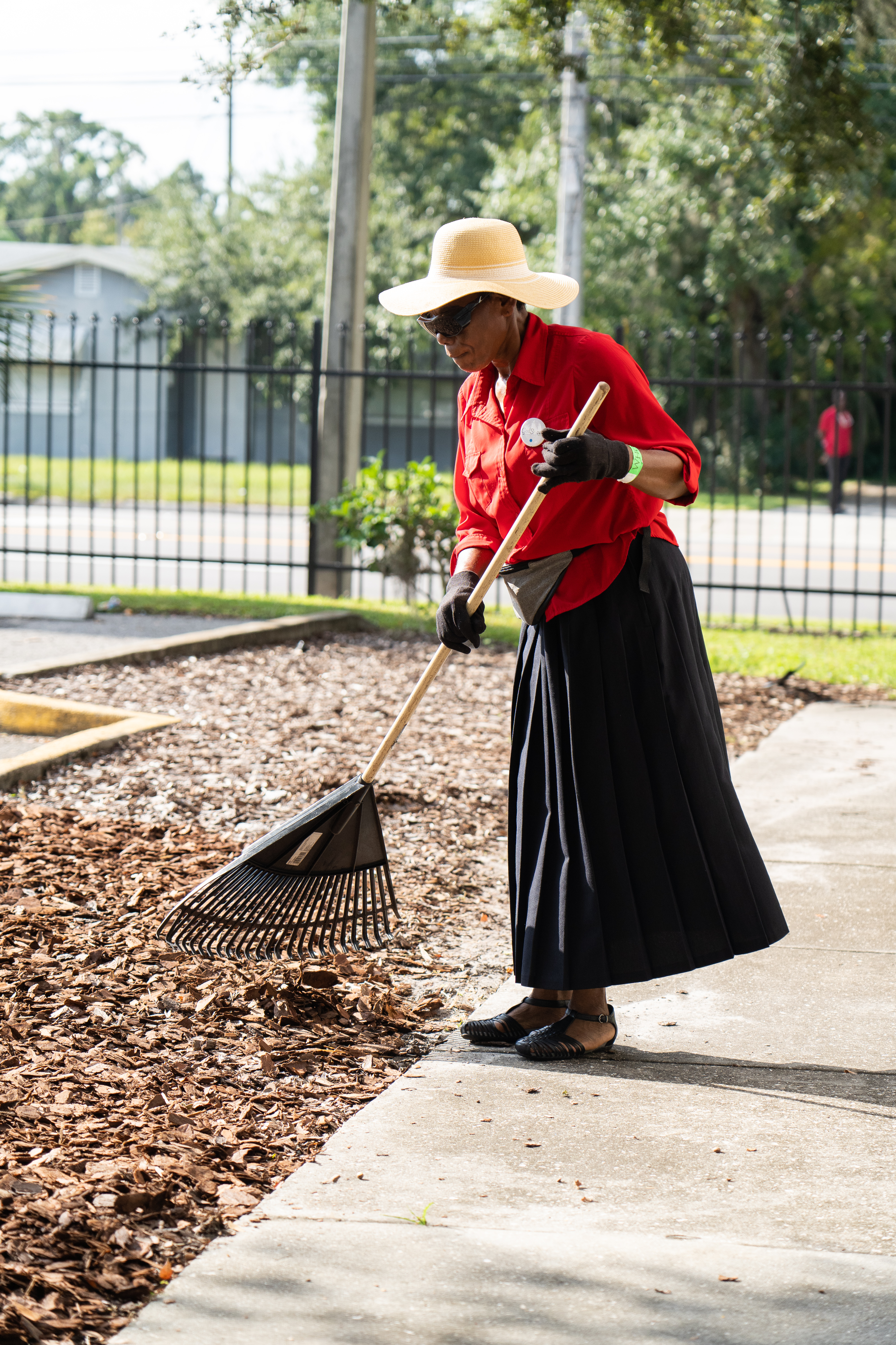 Volunteer arranges mulch on the grounds of the Orlando Union Rescue Mission. 