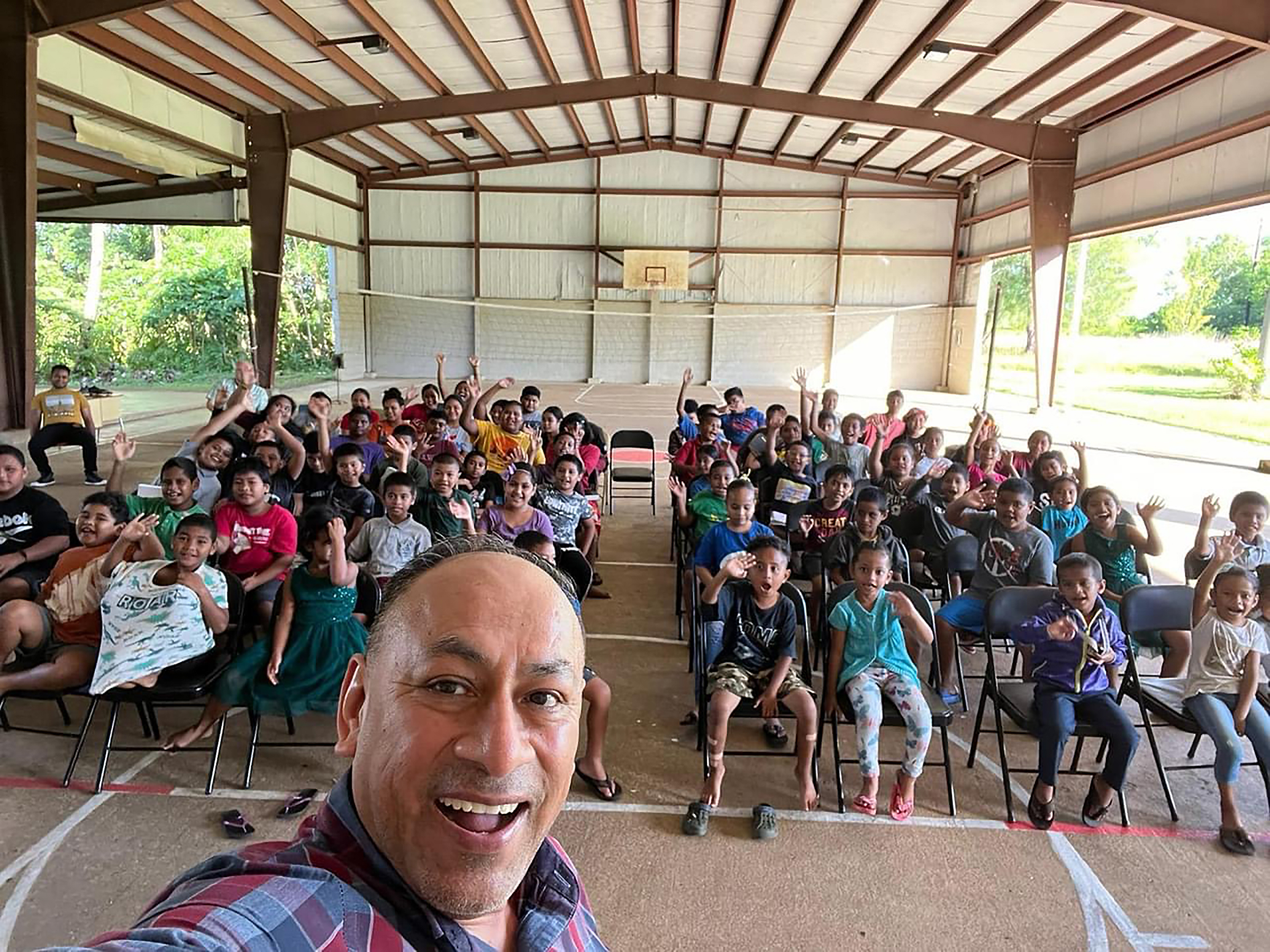 Selfie of a man, prominent, with several children in the background