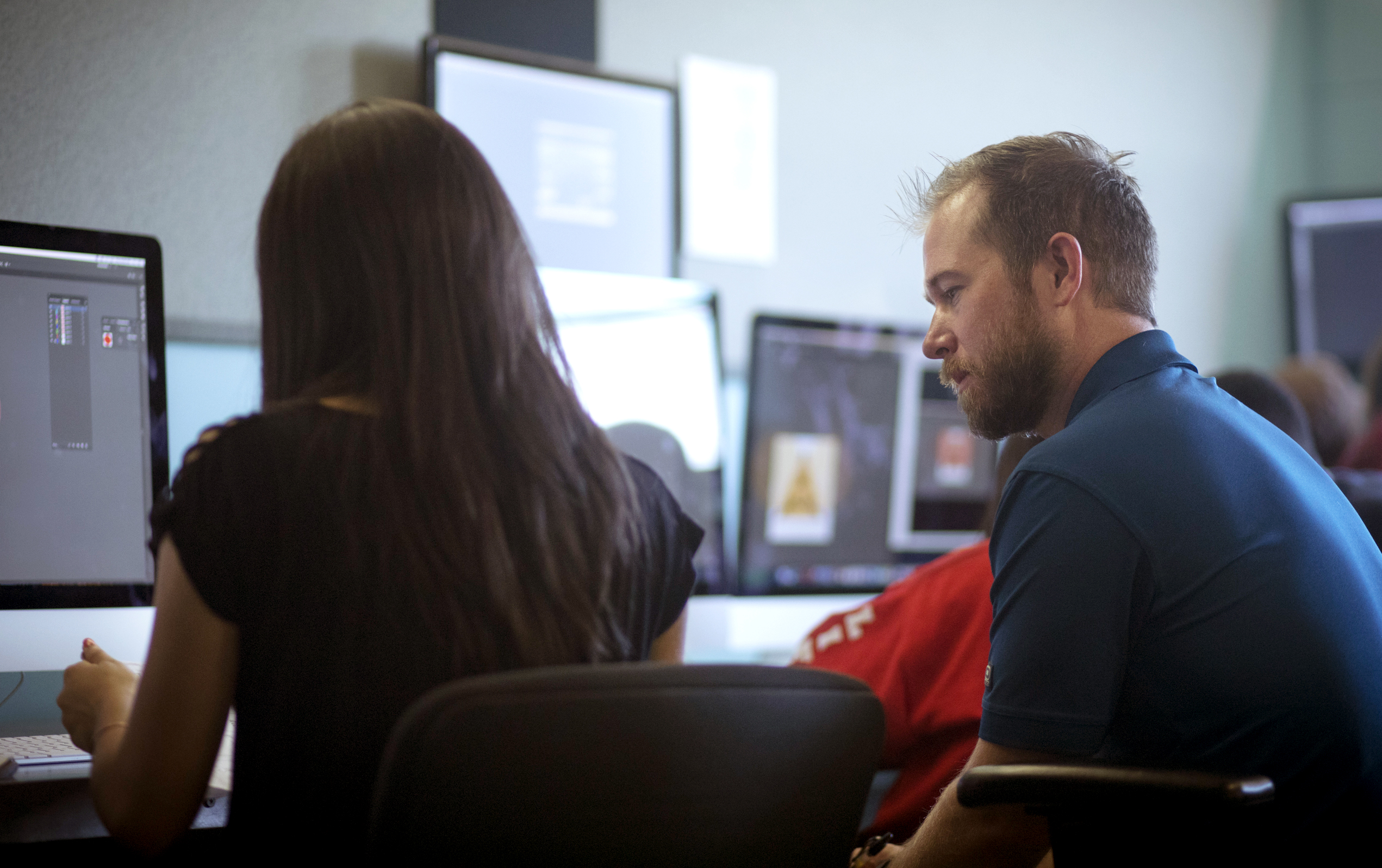 male professor and female student looking at a computer