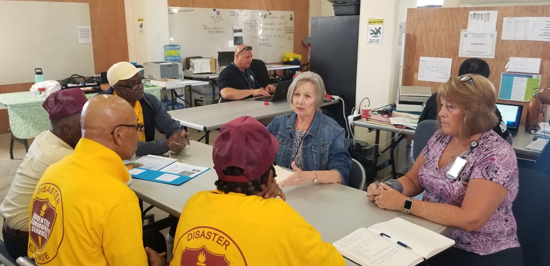 Representatives of the Federal Emergency Management Agency speak with volunteers of Adventist Community Services. 