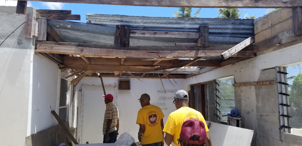 ACS volunteers walk through a damaged building in Saipan.