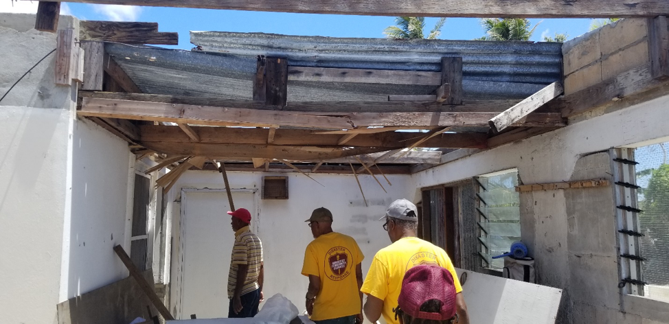 ACS volunteers walk through a damaged building in Saipan. 