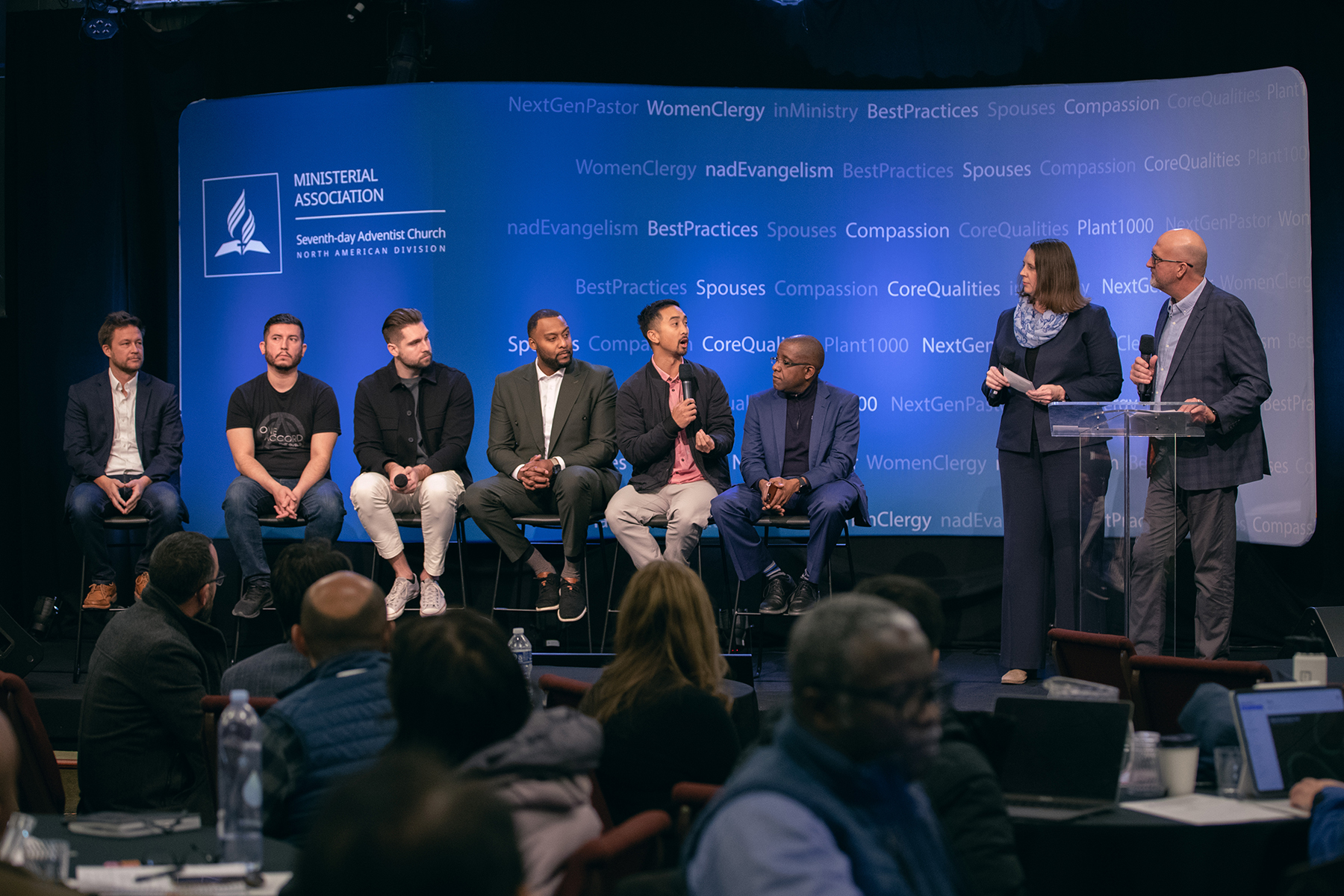 Several men of different ethnicities speak in a panel discussion