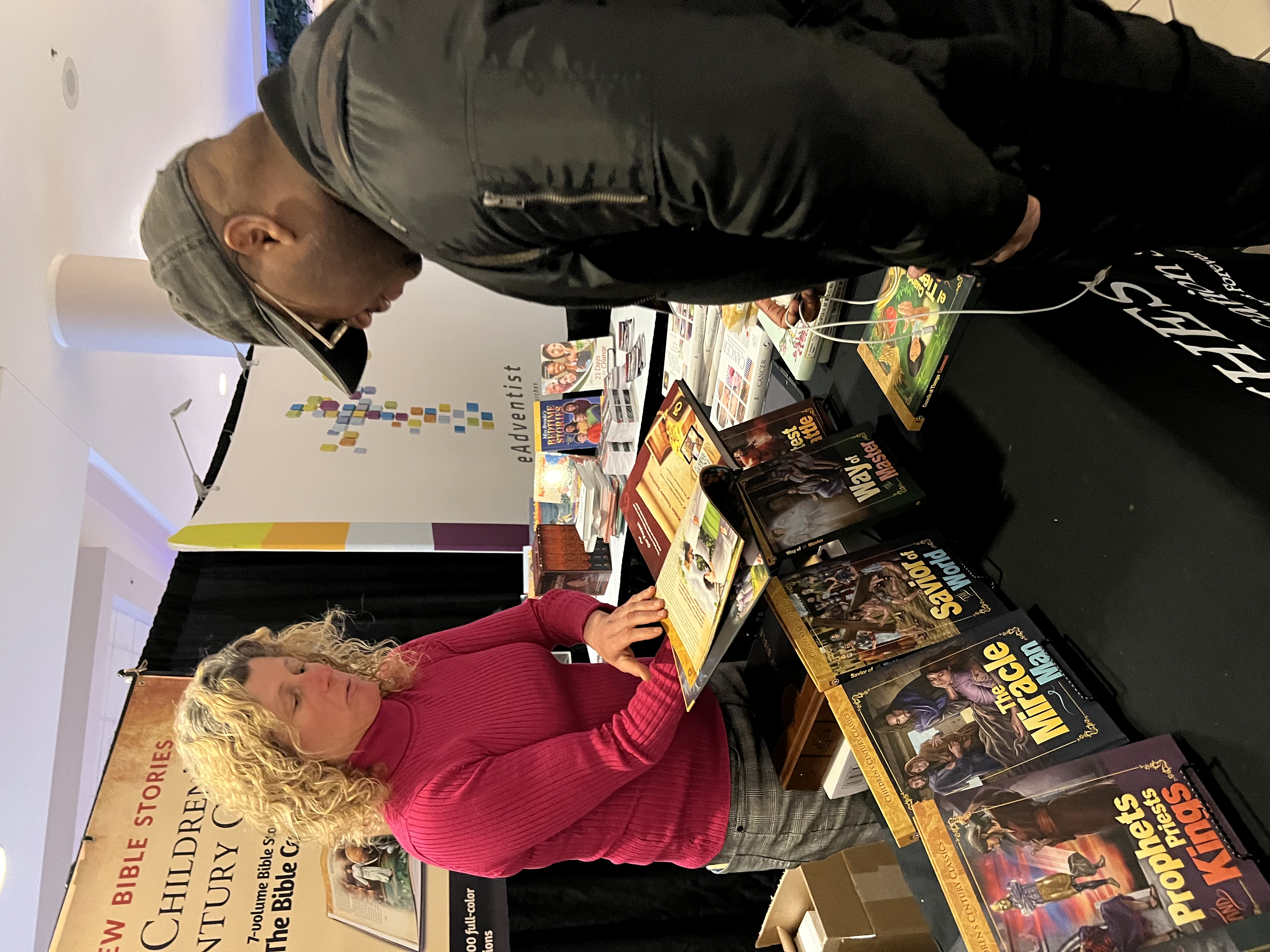 Tammy Mapes, a literature evangelist, engages with a potential customer in the exhibit hall of the North American Division's Adventist Ministries Convention