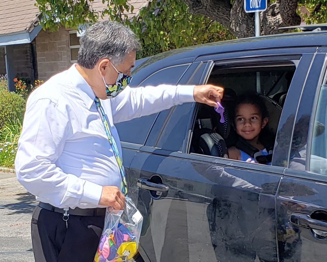 Pastor Phil gives a balloon to a child