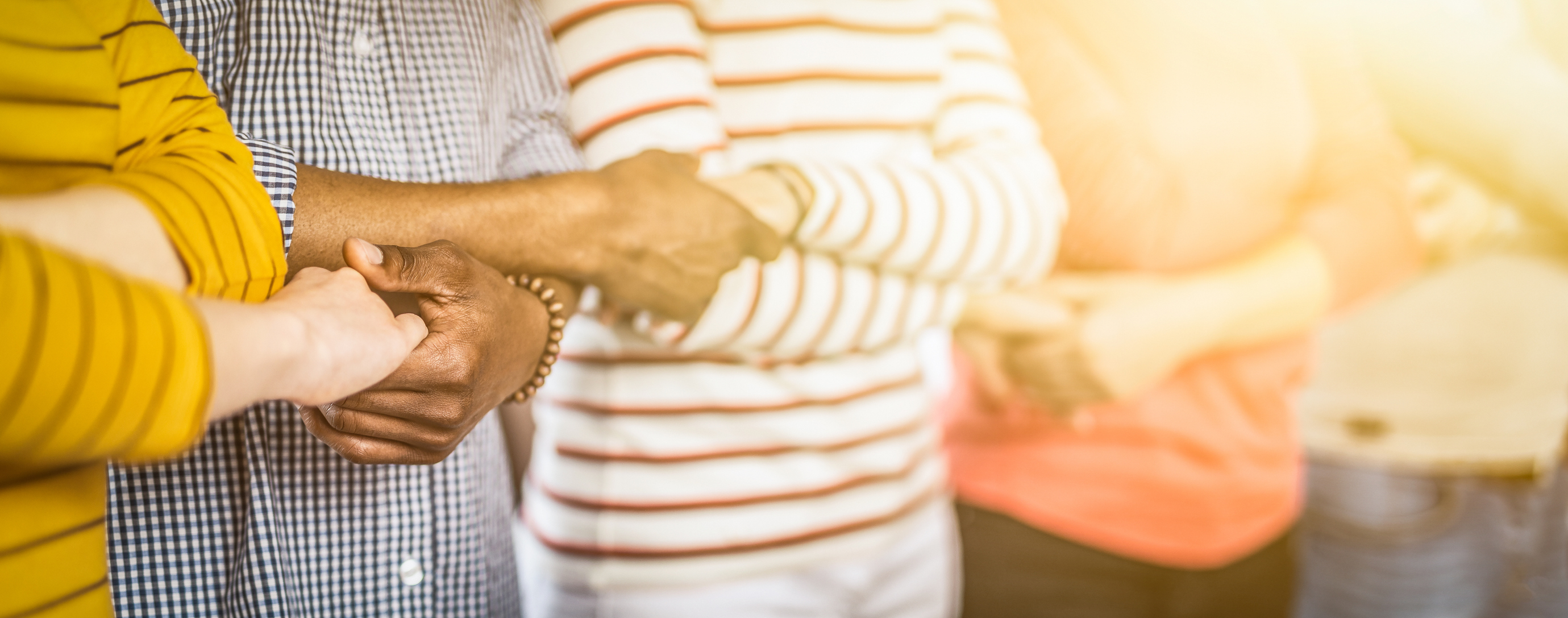 stock photo of diverse people linking arms