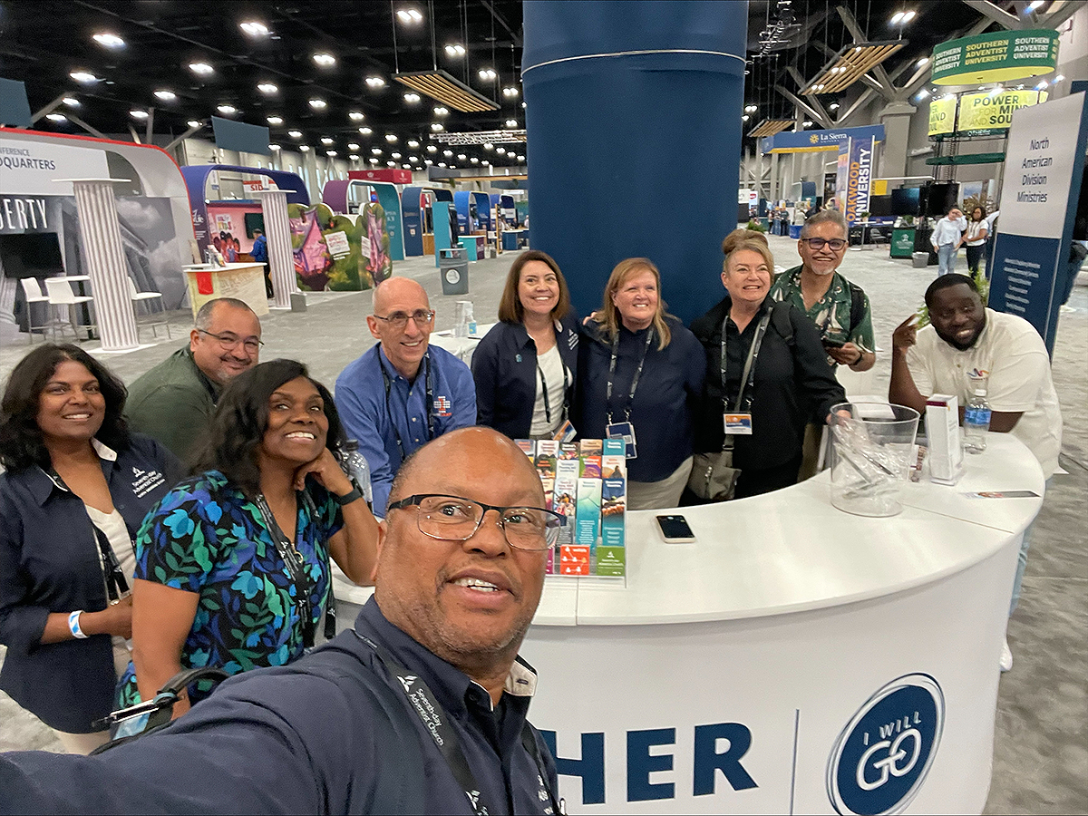 Photo of a diverse group in front of an exhibit booth