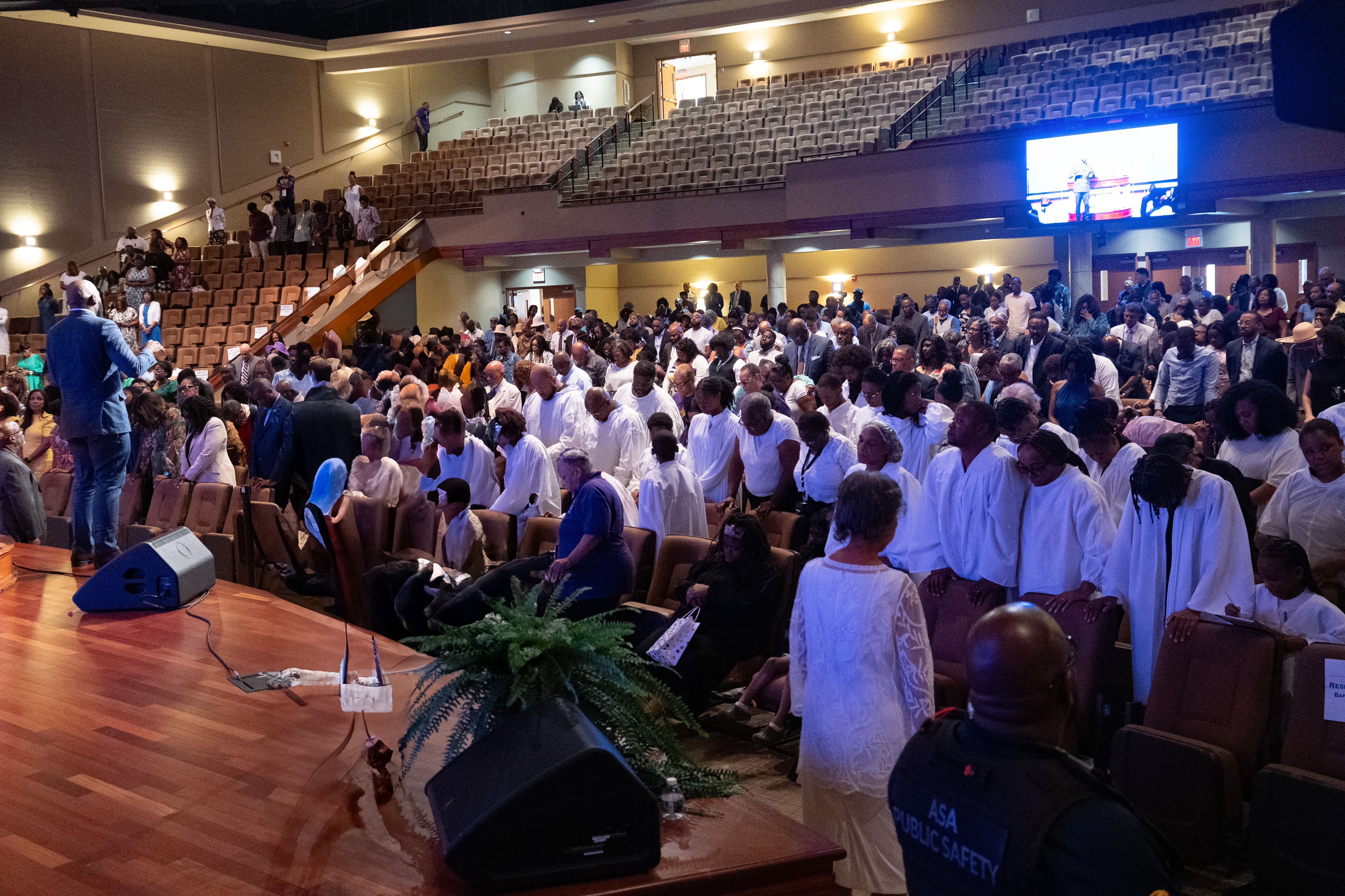 A congregation of people prepare for holy baptism.