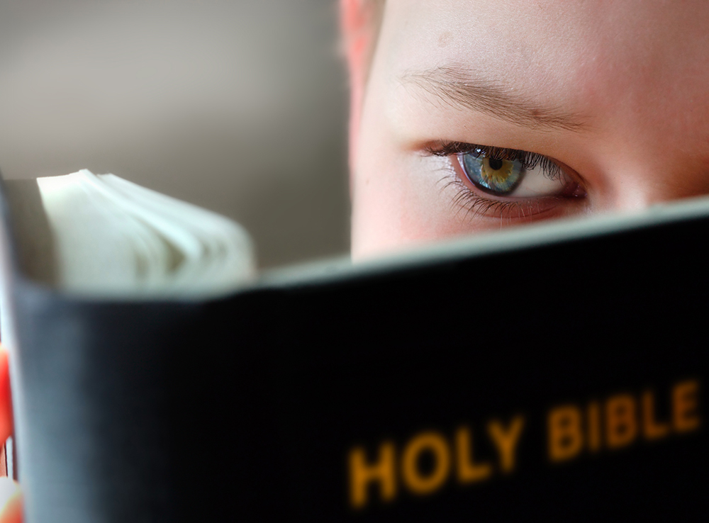Boy reading Bible close up