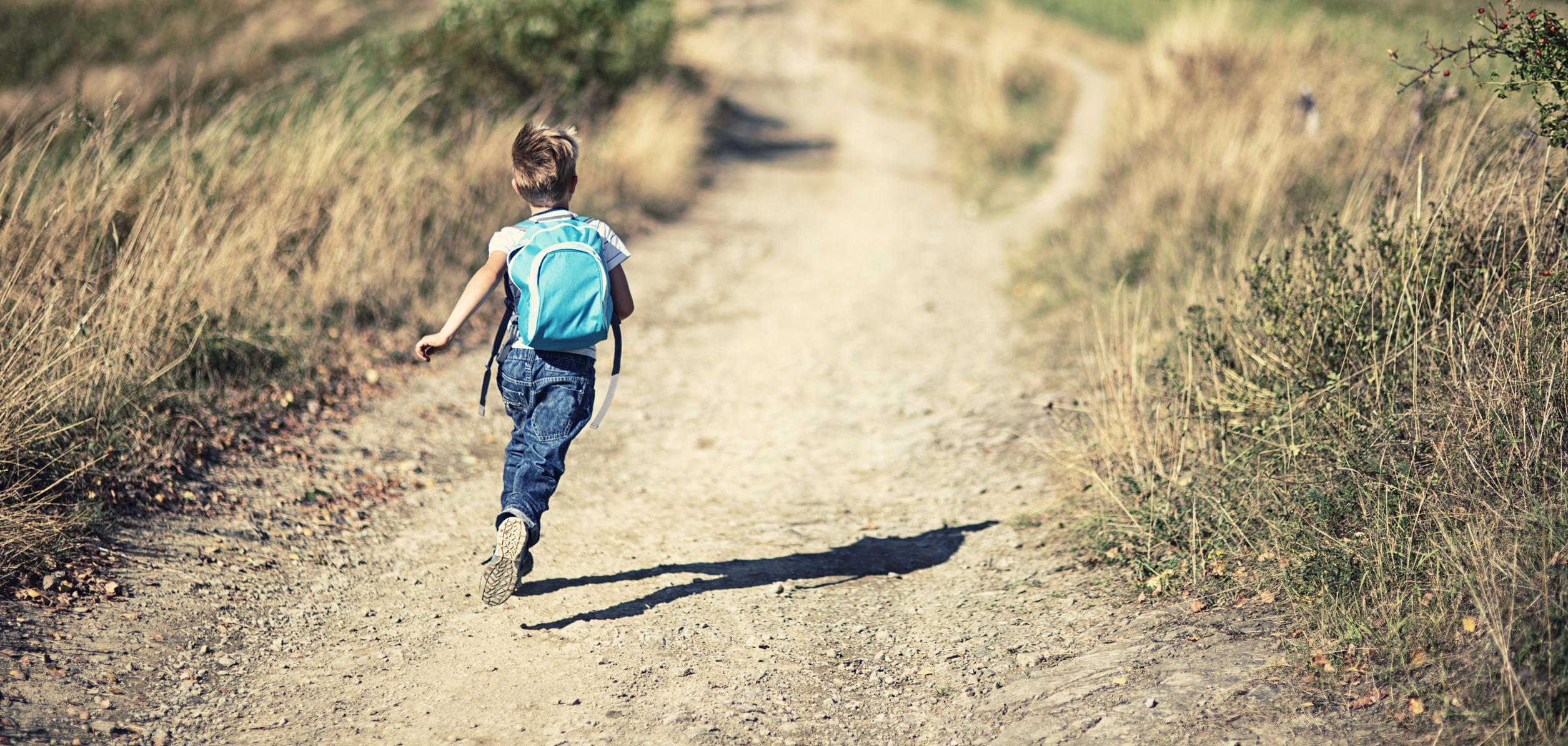 stock photo of boy running down dry road