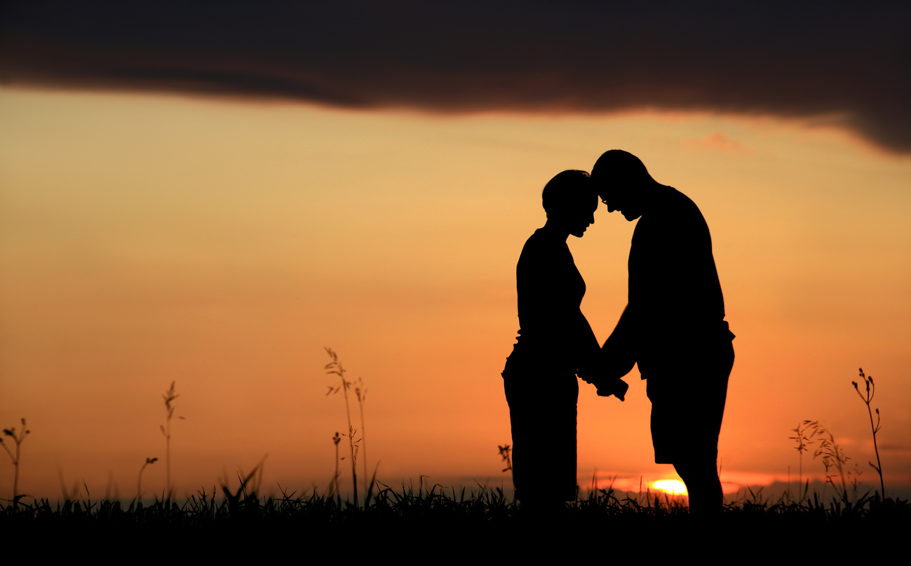stock photo of married couple holding hands sunset
