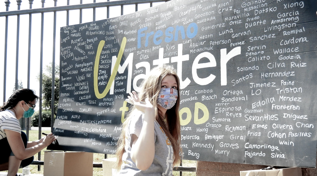 At the food giveaway at the Fresno Adventist Academy in California, a banner with signatures from volunteers greets those receiving food and literature.