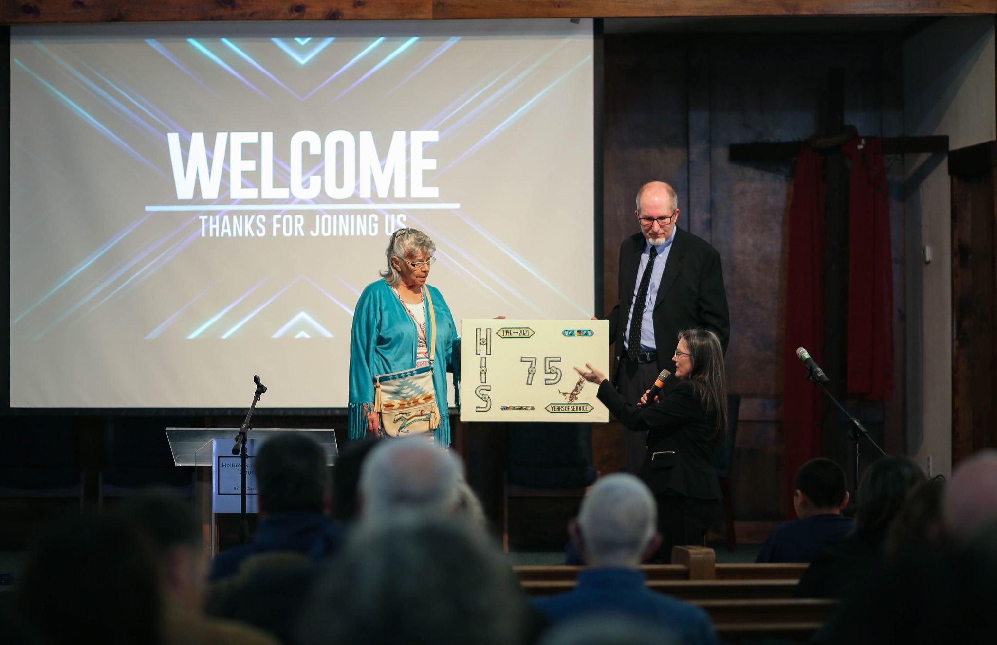 HIS volunteer Della Ault (left) presents the school with a gift to commemorate it’s 75th anniversary Photo Credit – HIS Facebook Page