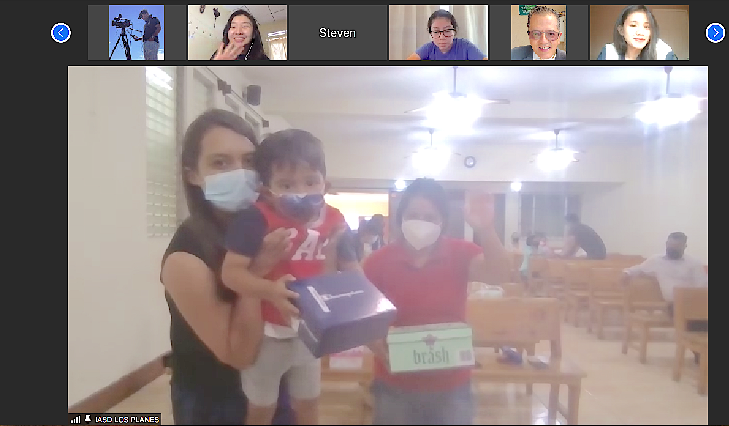 A family picks up boxes of new shoes at a Seventh-day Adventist church in Guatemala while an online audience cheers them on.