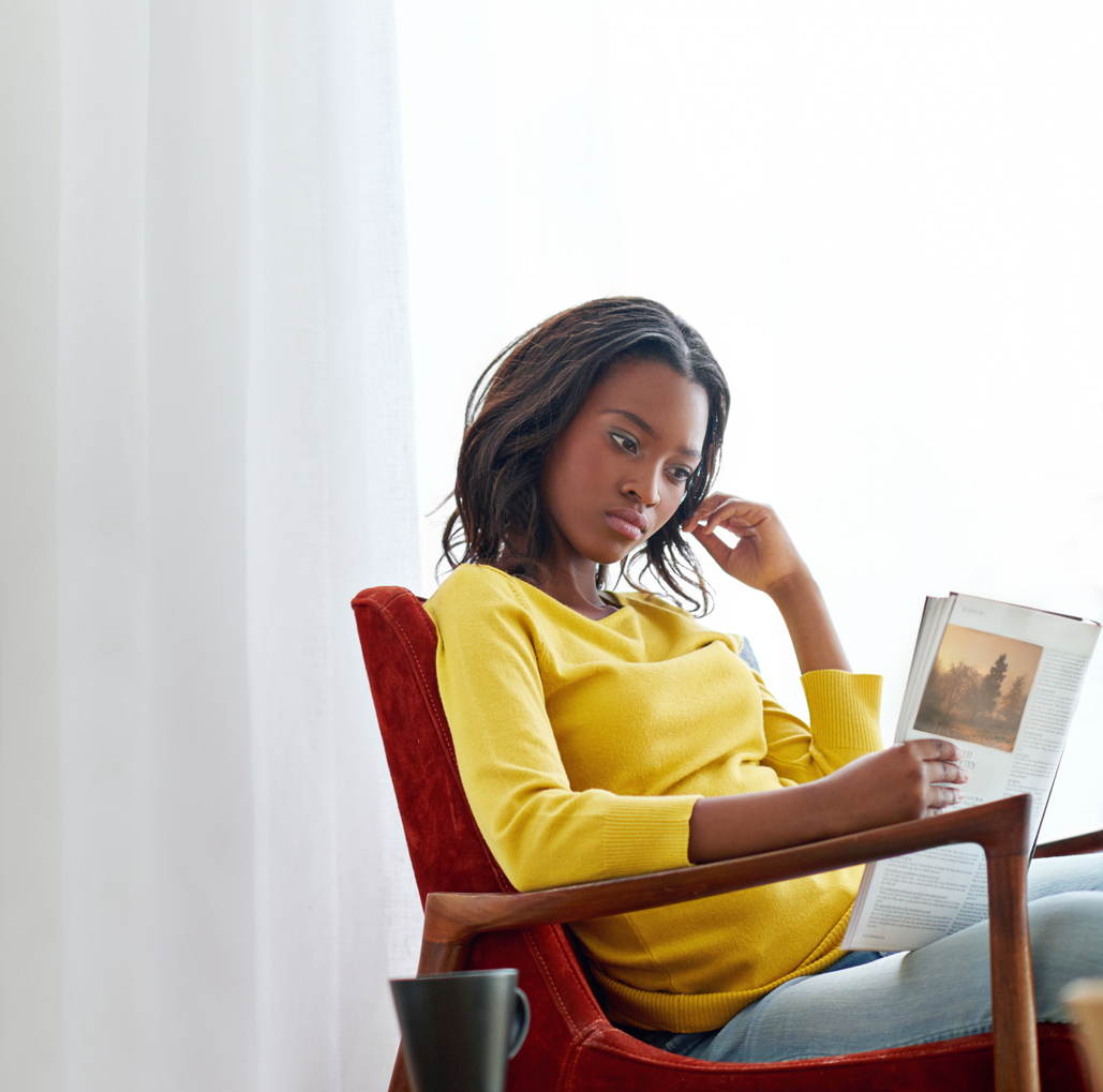 African American woman reading magazine