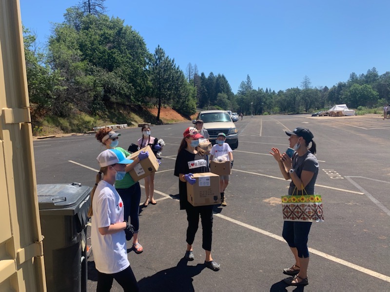 A delivery team gets their instructions as cars line up to receive boxes of fresh produce by Joelle Chinnock. In one day, 5,760 lbs. were distributed one 20 lb. box at a time for each family.   