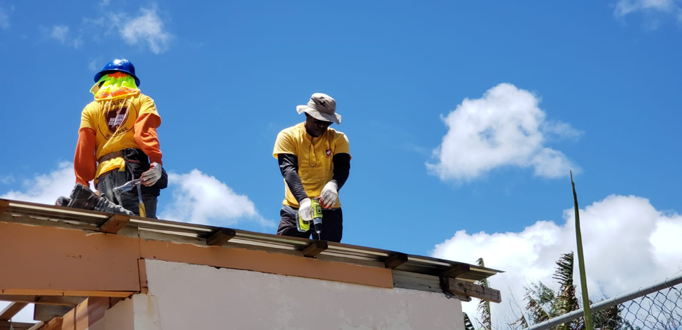 ACS volunteers work to replace a damaged roof. 