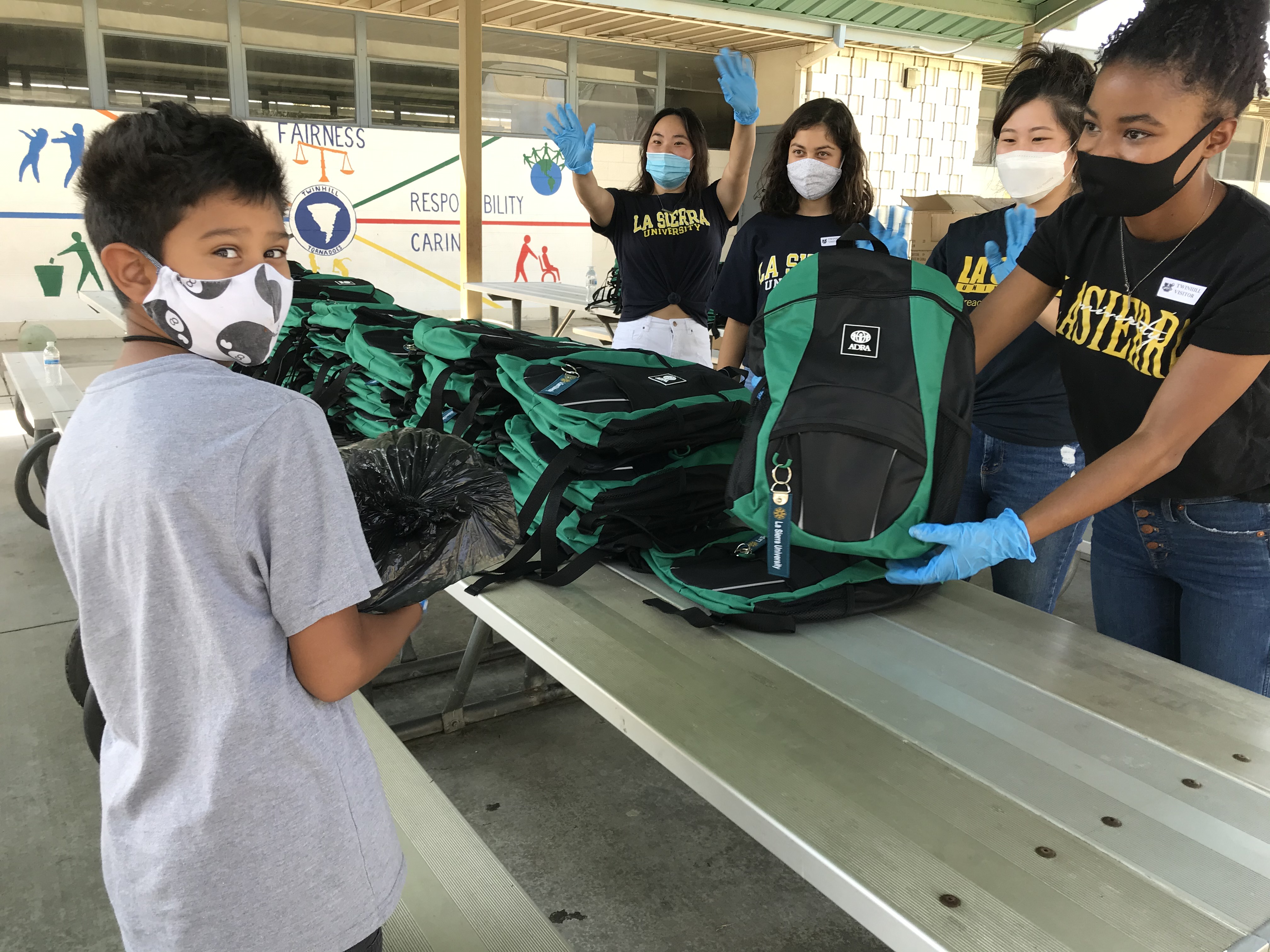 Third and 4th graders at Riverside’s Twinhill Elementary received filled backpacks on Friday, Aug. 28 a joint outreach between ADRA International and La Sierra University. La Sierra students left to right, Emily Suk, Shailani Skoretz, Ashley Peak and Jodi Wilson.