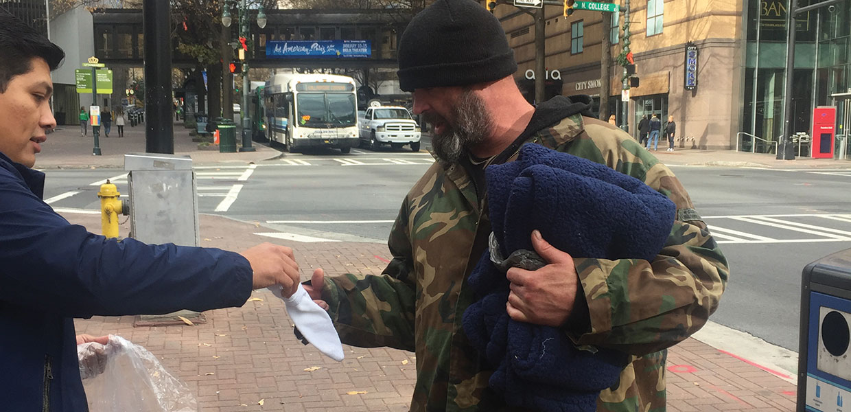 Charlotte spanish church member gives socks to homeless man