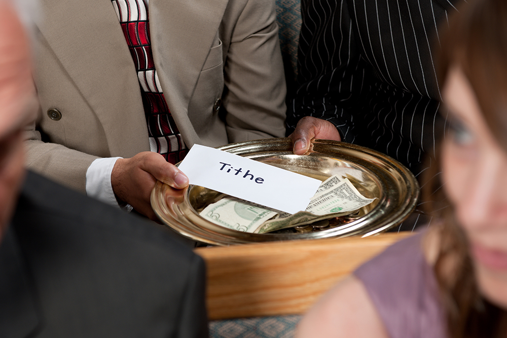 Stock photo of tithe and offering plate being passed at church
