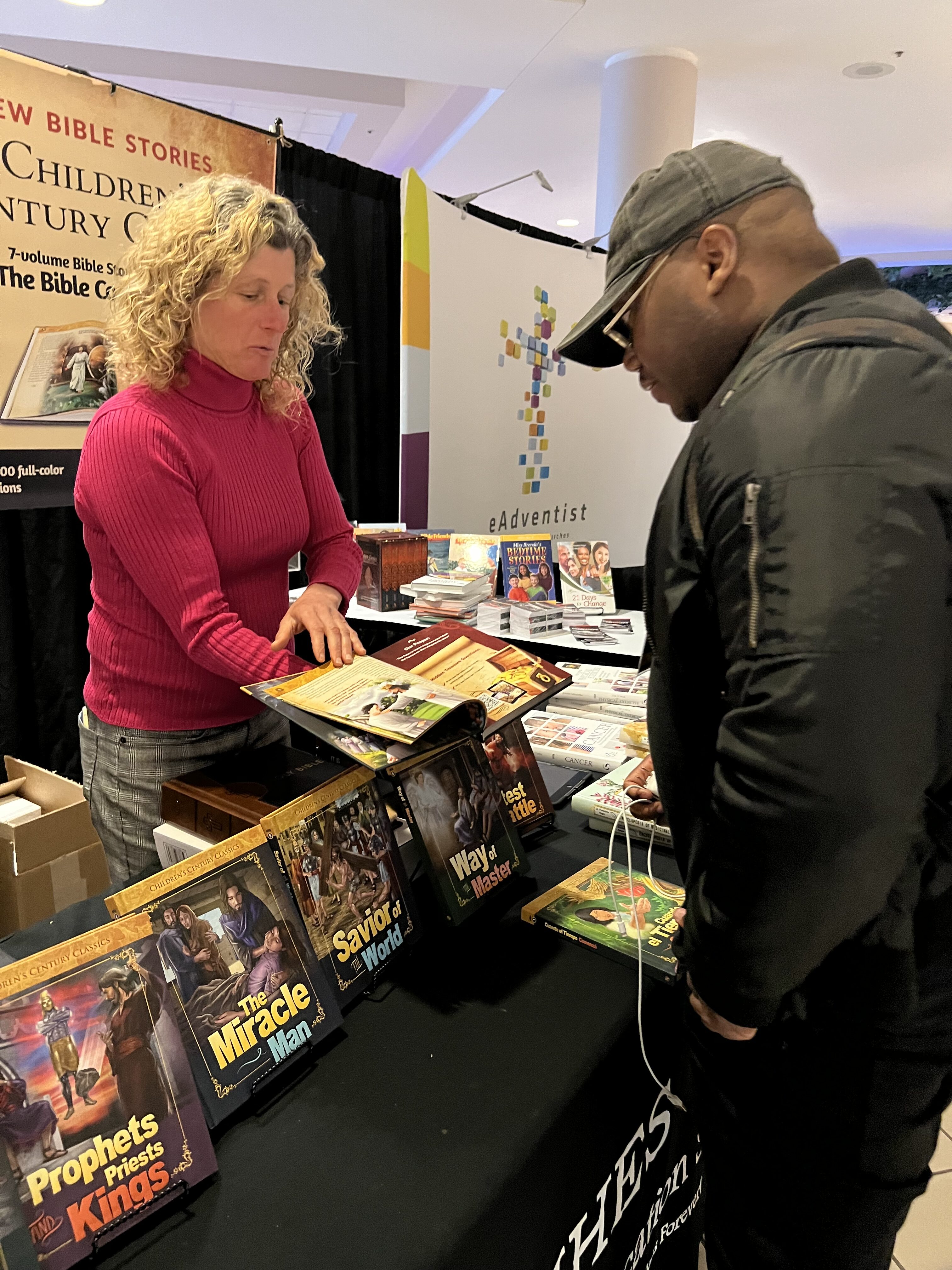 Tammy Mapes, a literature evangelist, engages with a potential customer in the exhibit hall of the North American Division's Adventist Ministries Convention
