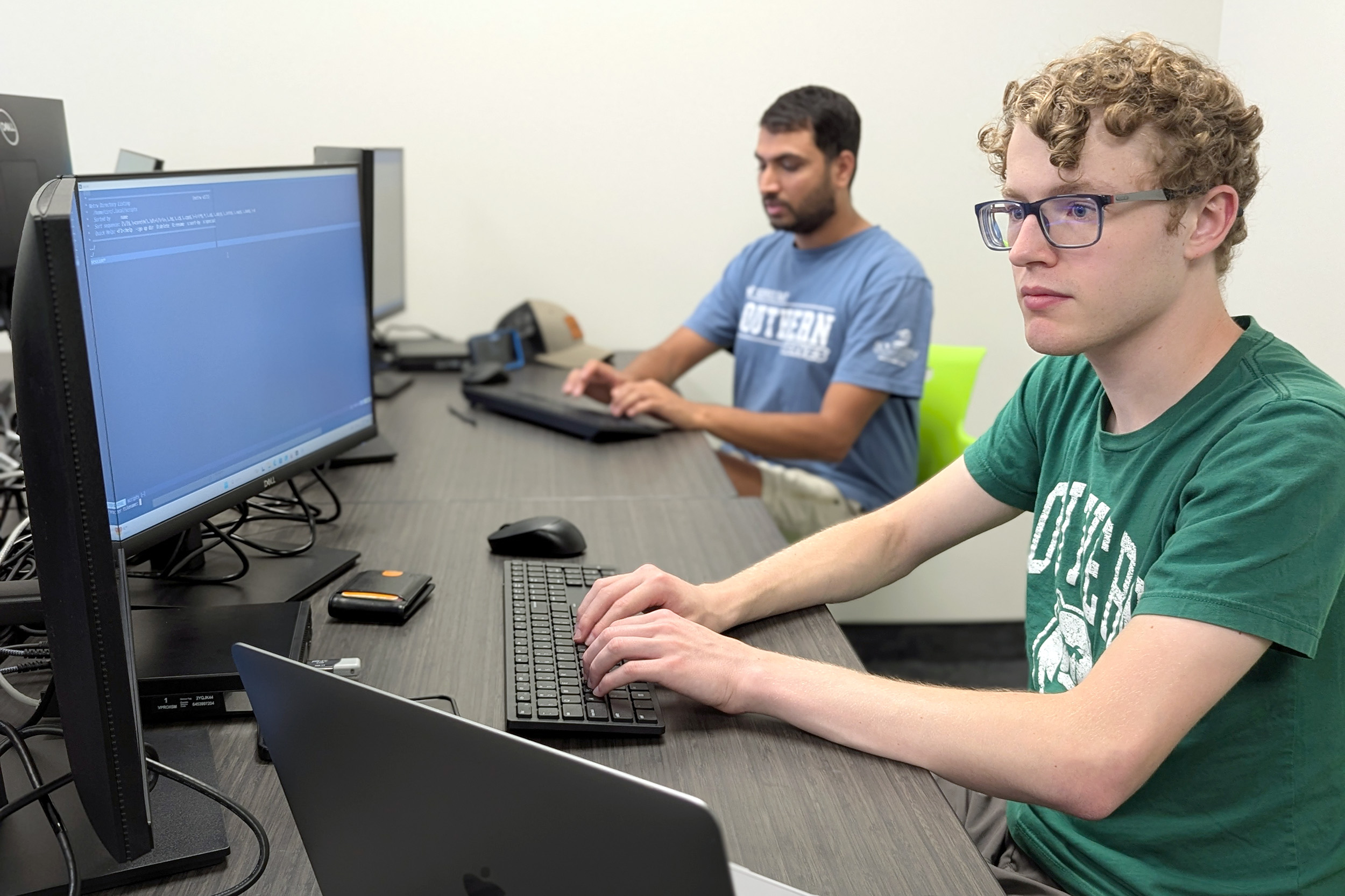 Two young adult males in a computer lab