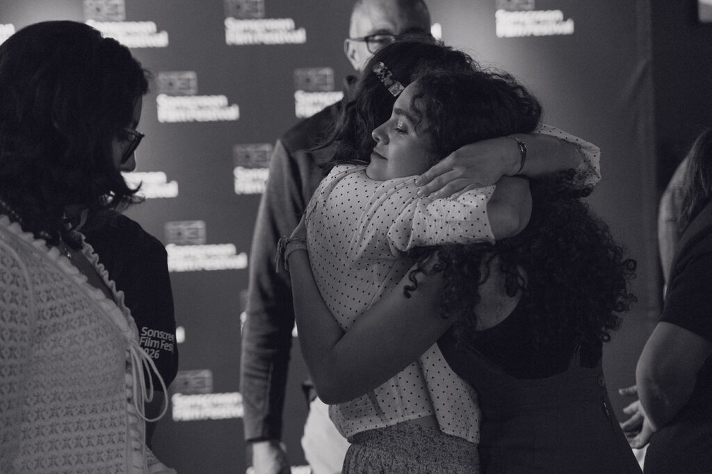 Black and white of two women hugging during Sonscreen Film Festival. 
