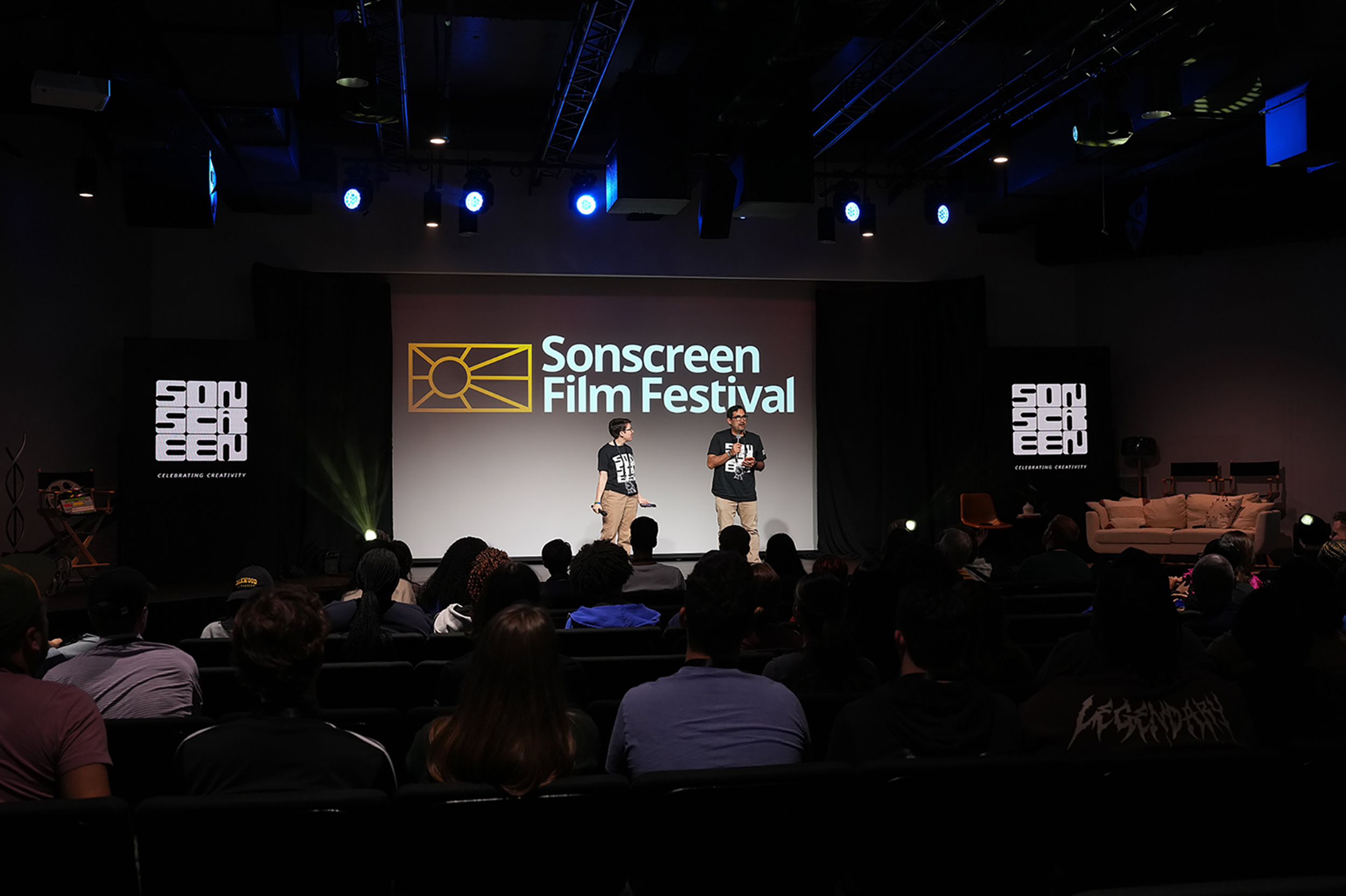 Wide shot of the Sonscreen film festival with co-directors on stage
