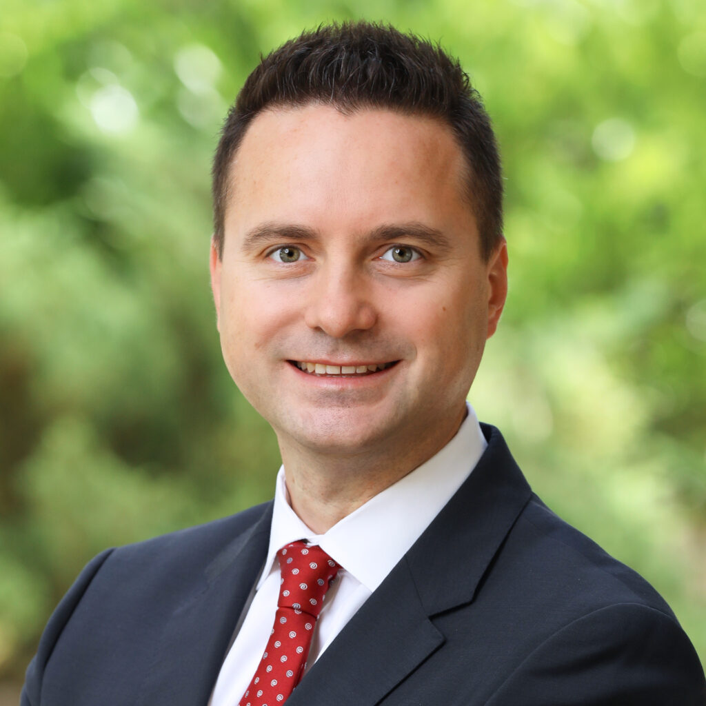 Professional headshot of a man in a dark suit