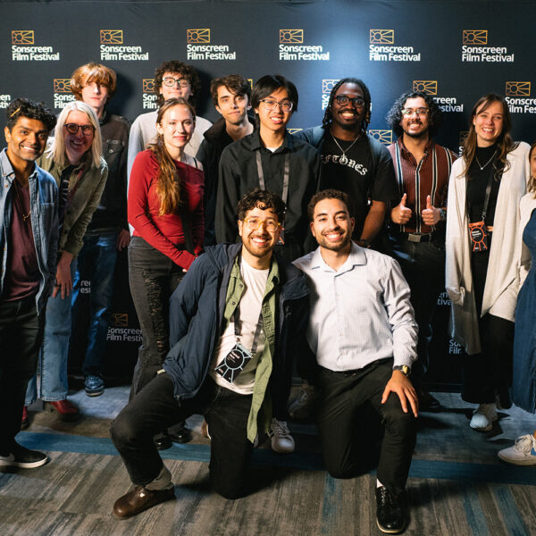 Group of college students posing in front of a film festival step-and-repeat backdrop